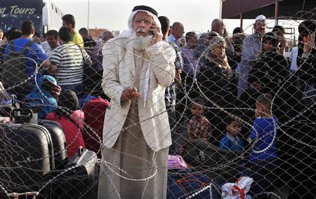 Palestinian man speaks on the phone as he waits at Rafah crossing between Egypt and southern Gaza Strip with hopes of crossing into Egypt